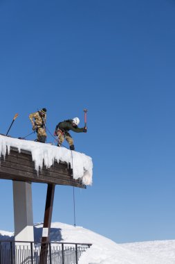 Sochi, Rusya Federasyonu - 22 Ocak 2015: kar ve buz sarkıtları çatıdan endüstriyel dağcılar çıkar