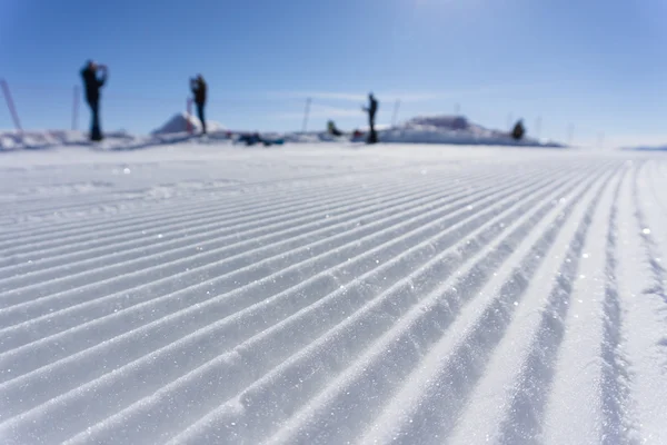 Pistes de dameuse fraîche sur une piste de ski — Photo