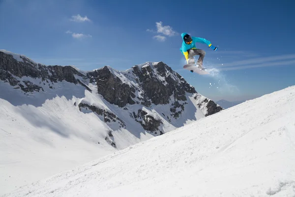 Flygande snowboardåkare på fjället. Extrem sport — Stockfoto