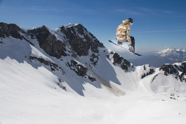 Repülő snowboardos a hegyekben. Extrém sport — Stock Fotó