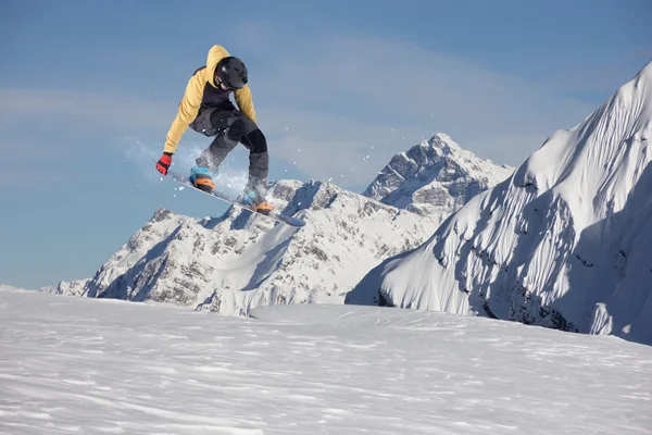 Vliegende snowboarder op de bergen. Extreme sport — Stockfoto