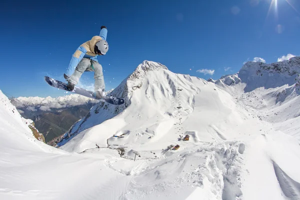 Flygande snowboardåkare på fjället. Extrem sport — Stockfoto