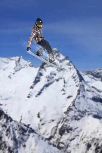 Um snowboarder voador nas montanhas. Desporto extremo — Fotografia de Stock