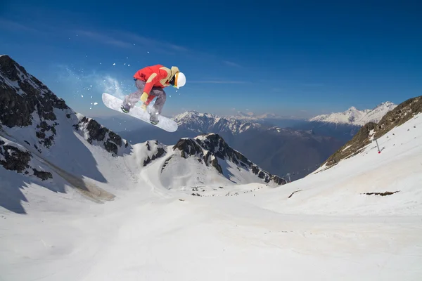 Flygande snowboardåkare på fjället. Extrem sport. — Stockfoto