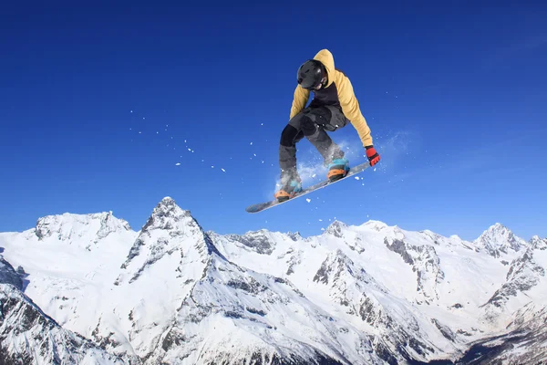 Um snowboarder voador nas montanhas. Desporto extremo. — Fotografia de Stock