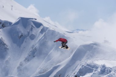 Dağlarda uçan snowboardcu. Sıra dışı spor.