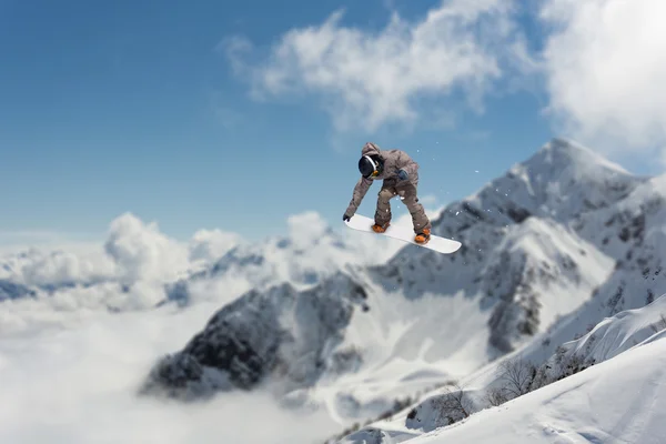 Flygande snowboardåkare på fjället. Extrem sport. — Stockfoto