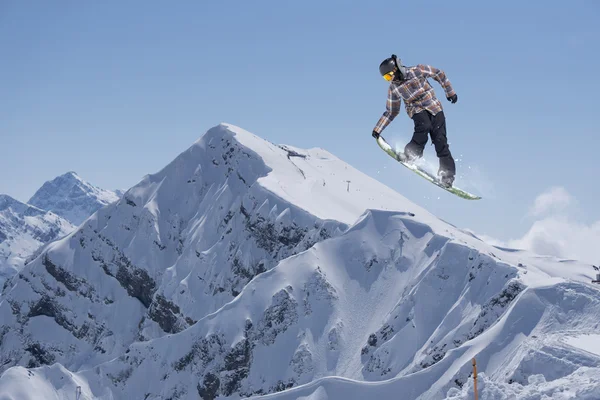 Repülő snowboardos a hegyekben. Extrém sport. — Stock Fotó