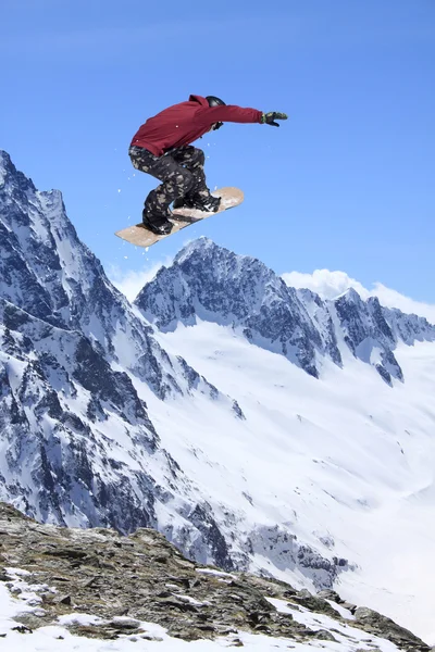 Um snowboarder voador nas montanhas. Desporto extremo. — Fotografia de Stock