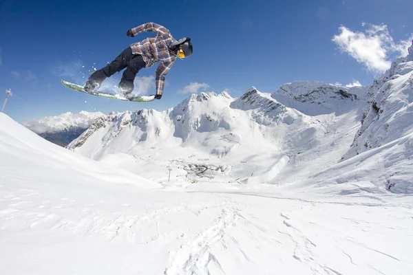 Flygande snowboardåkare på fjället. Extrem sport. — Stockfoto