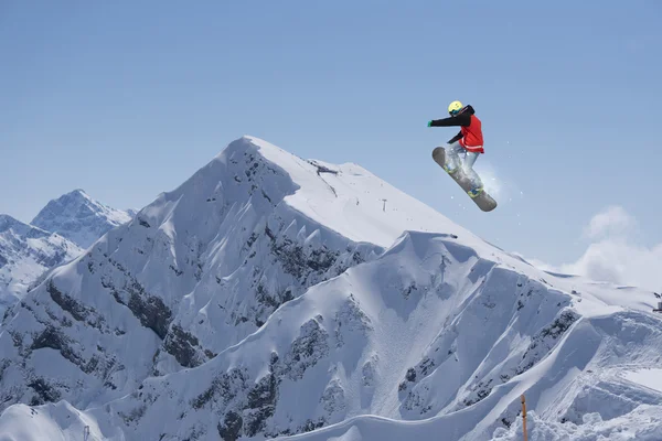 Um snowboarder voador nas montanhas. Desporto extremo. — Fotografia de Stock