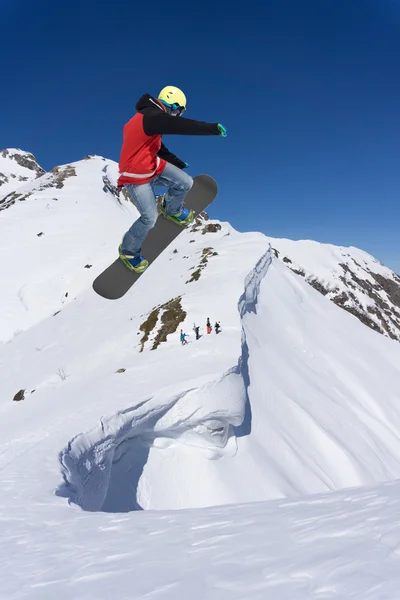 Ιπτάμενος snowboarder στα βουνά. Ακραίο άθλημα. — Φωτογραφία Αρχείου