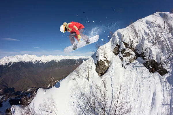 Um snowboarder voador nas montanhas. Desporto extremo. — Fotografia de Stock