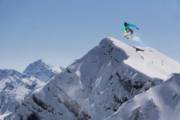 Um snowboarder voador nas montanhas. Desporto extremo. — Fotografia de Stock