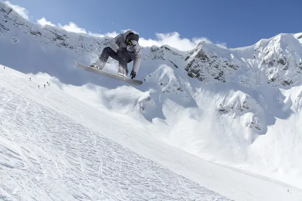 Um snowboarder voador nas montanhas. Desporto extremo. — Fotografia de Stock