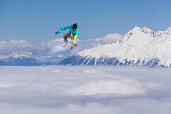 Um snowboarder voador nas montanhas. Desporto extremo. — Fotografia de Stock