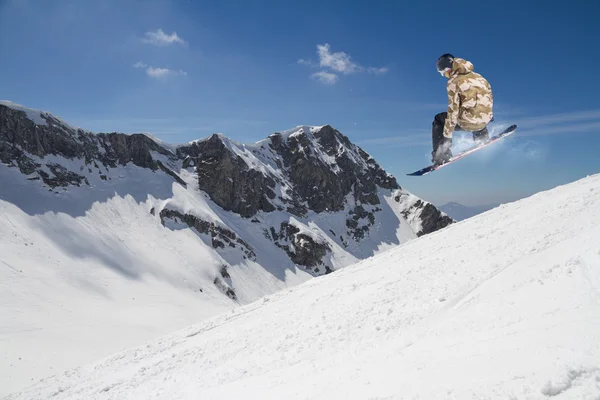 Flygande snowboardåkare på fjället. Extrem sport. — Stockfoto