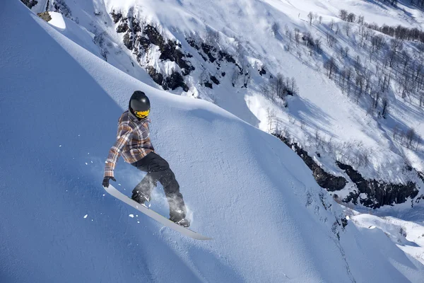 Um snowboarder voador nas montanhas. Desporto extremo. — Fotografia de Stock