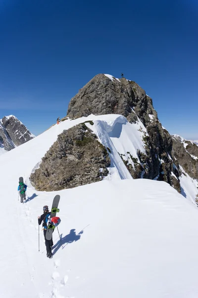 Snowboarders caminando cuesta arriba para freeride — Foto de Stock