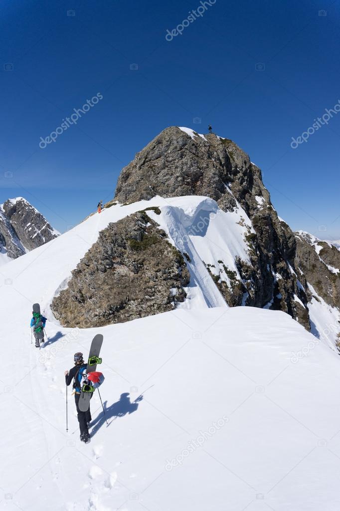 Snowboarders walking uphill for freeride