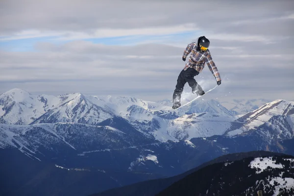 Létající snowboardista na horách. Extrémní sport. — Stock fotografie