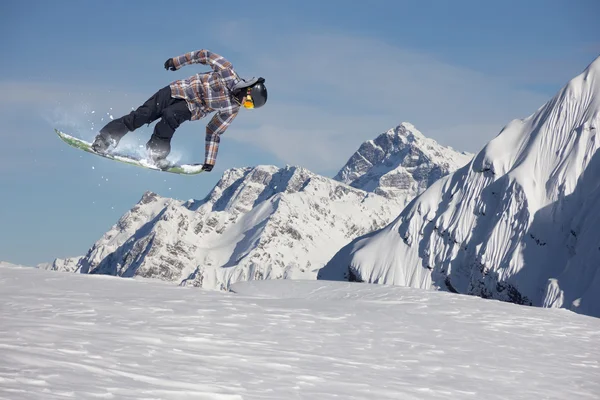 Um snowboarder voador nas montanhas. Desporto extremo. — Fotografia de Stock