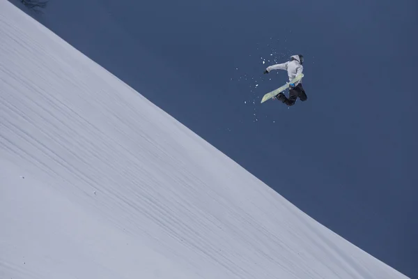 Um snowboarder voador nas montanhas. Desporto extremo. — Fotografia de Stock