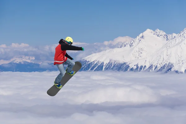 Um snowboarder voador nas montanhas. Desporto extremo. — Fotografia de Stock