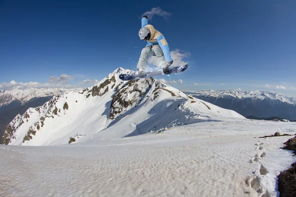 Flygande snowboardåkare på fjället. Extrem sport. — Stockfoto