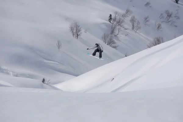 Flygande snowboardåkare på fjället. Extrem sport. — Stockfoto