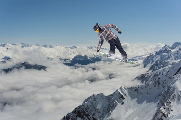 Fliegender Snowboarder auf den Bergen. Extremsport. — Stockfoto