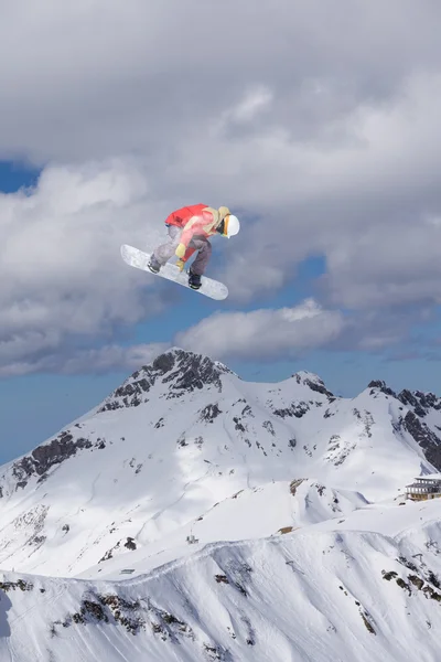 Flygande snowboardåkare på fjället. Extrem sport. — Stockfoto