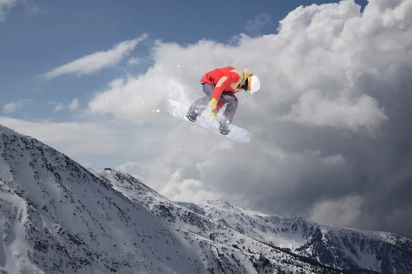 Flygande snowboardåkare på fjället. Extrem sport. — Stockfoto