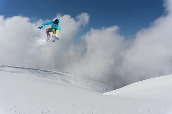 Flying snowboarder on mountains. Extreme sport.