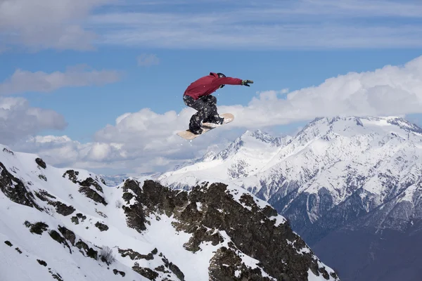 Repülő snowboardos a hegyekben. Extrém sport. — Stock Fotó