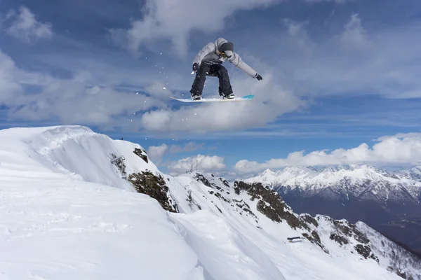 Um snowboarder voador nas montanhas. Desporto extremo. — Fotografia de Stock