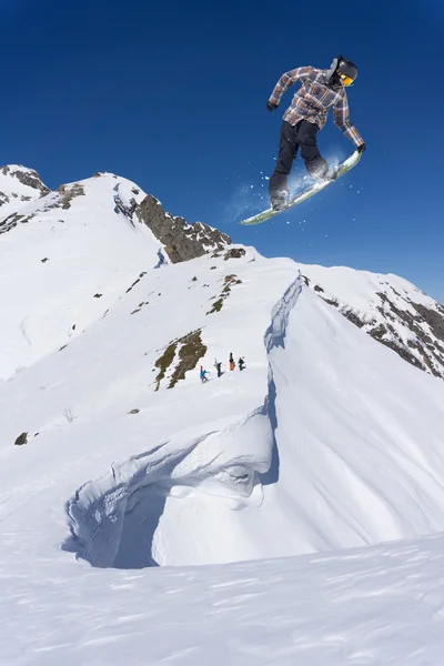 Fliegender Snowboarder auf den Bergen. Extremsport. — Stockfoto