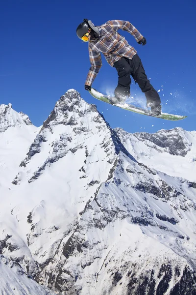 Flygande snowboardåkare på fjället. Extrem sport. — Stockfoto