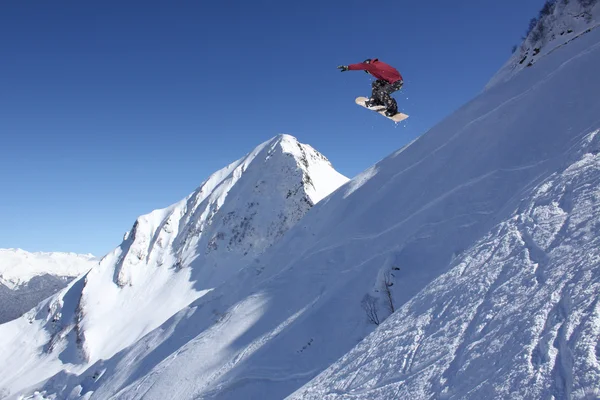 Fliegender Snowboarder auf den Bergen. Extremsport. — Stockfoto