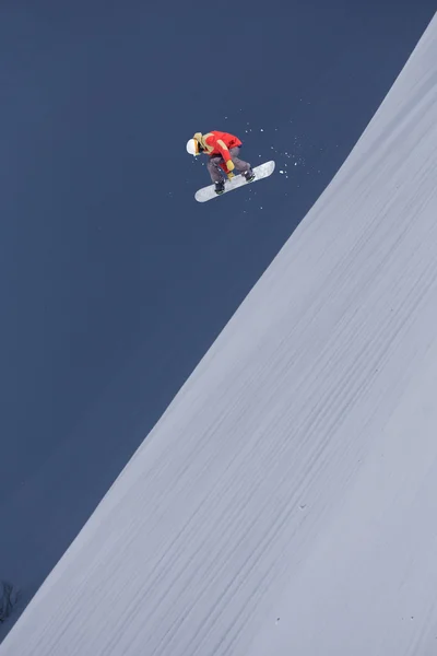 Um snowboarder voador nas montanhas. Desporto extremo. — Fotografia de Stock