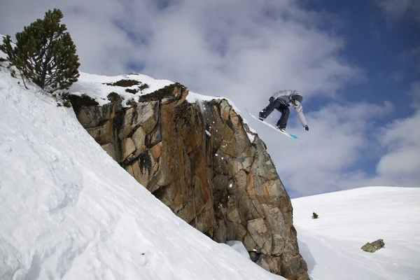 Um snowboarder voador nas montanhas. Desporto extremo. — Fotografia de Stock