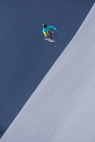 Repülő snowboardos a hegyekben. Extrém sport. — Stock Fotó