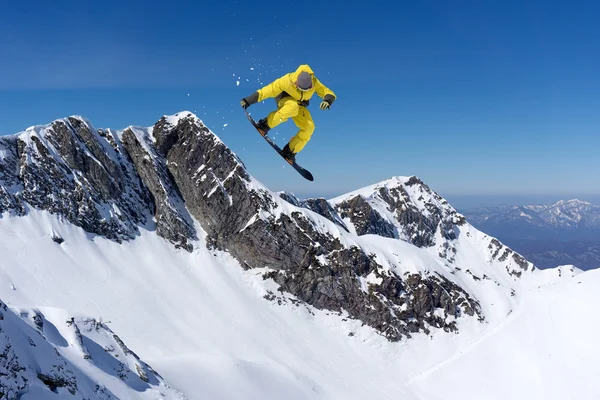 Vliegende snowboarder op de bergen. Extreme sport. — Stockfoto