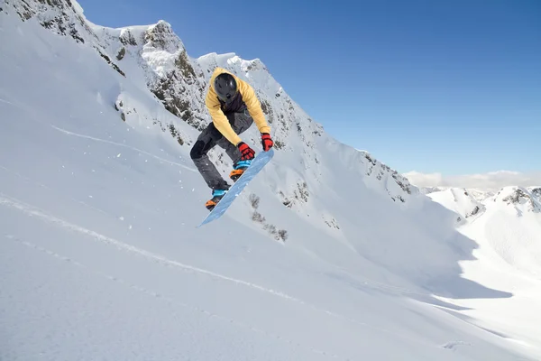 Um snowboarder voador nas montanhas. Desporto extremo. — Fotografia de Stock