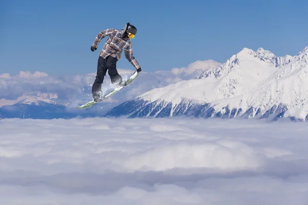 Um snowboarder voador nas montanhas. Desporto extremo. — Fotografia de Stock