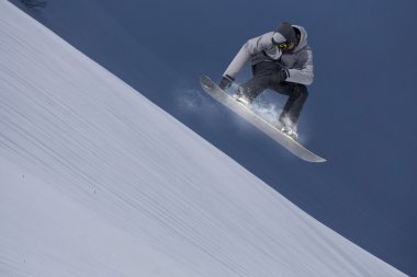 Dağlarda uçan snowboardcu. Sıra dışı spor.