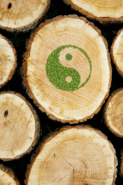 Hintergrund gestapelte Baumstämme mit Ying-Yang-Symbol — Stockfoto