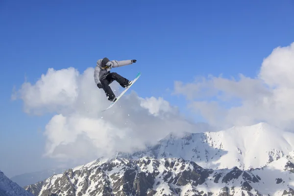 Flygande snowboardåkare på fjället. Extrem sport. — Stockfoto