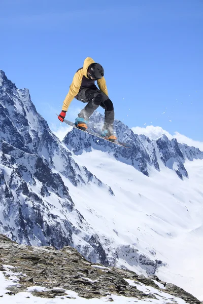 Flygande snowboardåkare på fjället. Extrem sport. — Stockfoto