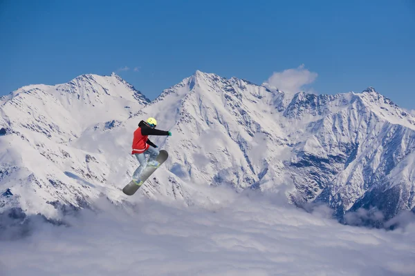 Um snowboarder voador nas montanhas. Desporto extremo. — Fotografia de Stock